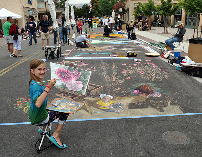 Girl poses with unfinished street painting